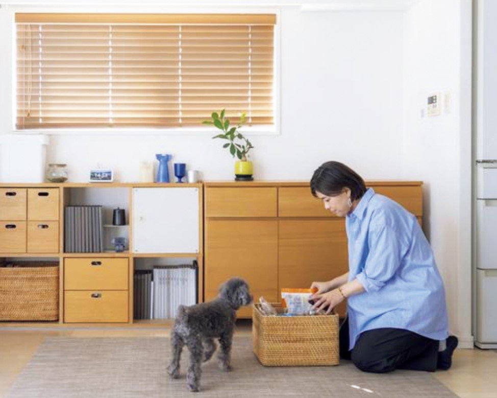 収納棚を確認する女性と犬