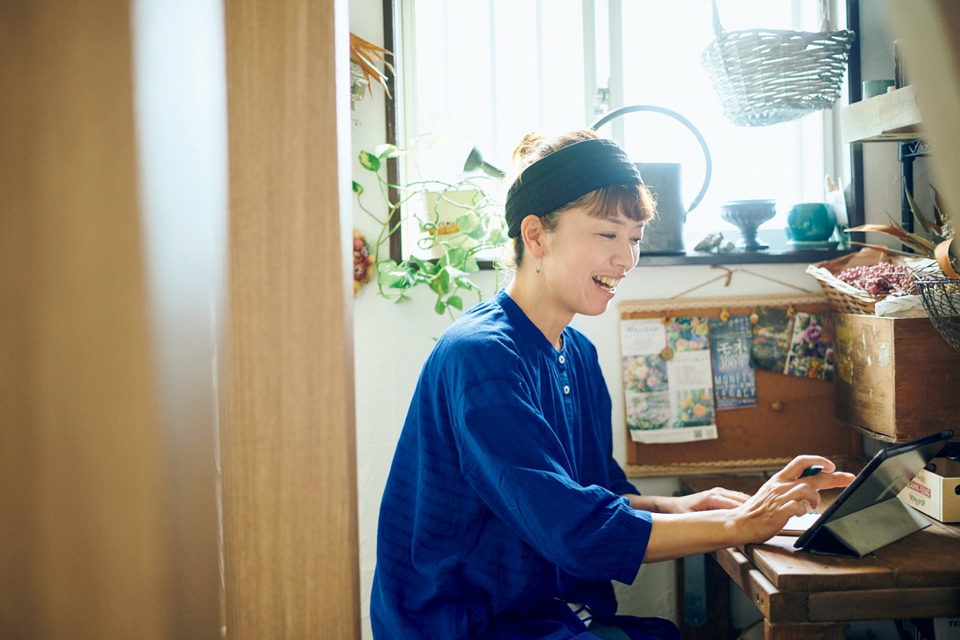 部屋でタブレットを見る女性
